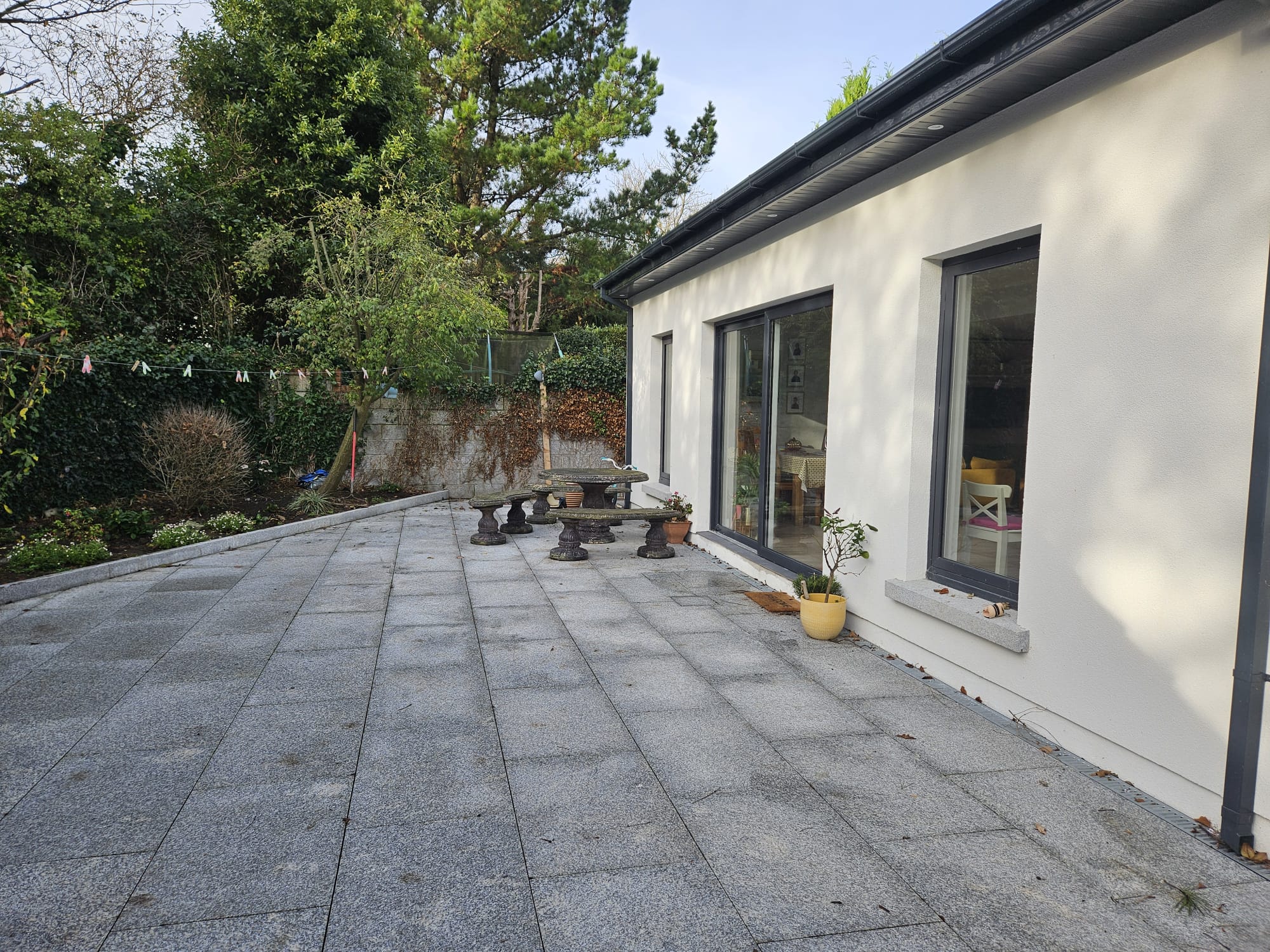 Rendered rear extension with large glazed doors opening onto a paved patio
