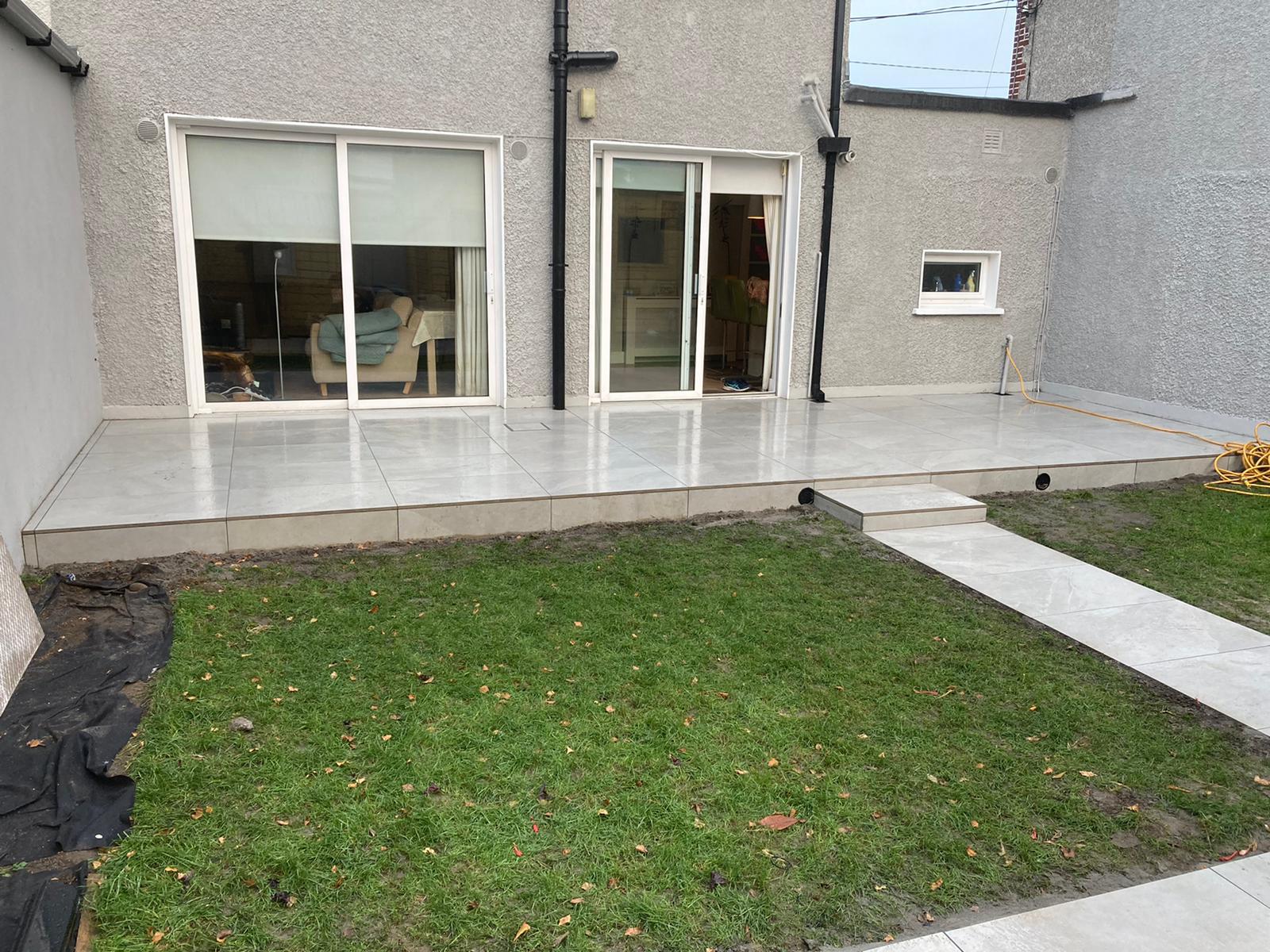 Finished light porcelain patio with stepped edge and reinstated lawn
