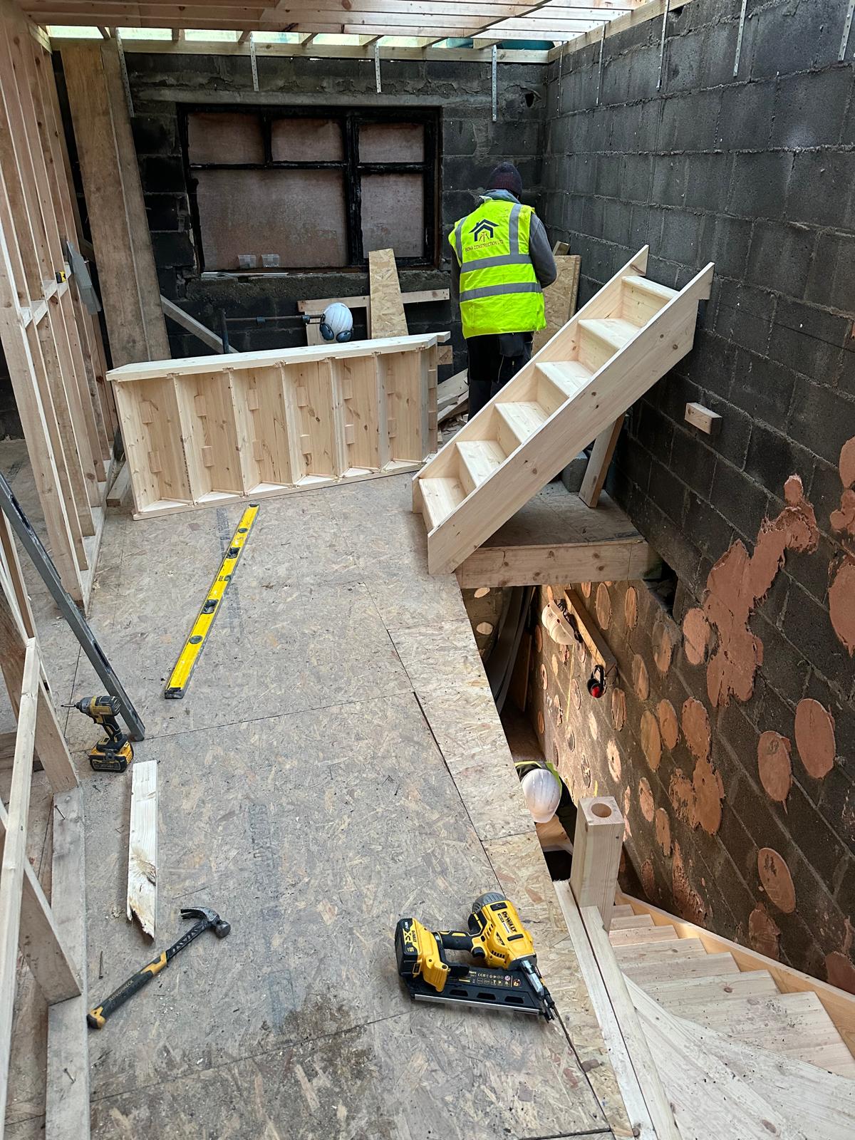 Bespoke timber staircase being fitted by a Bona Construction carpenter