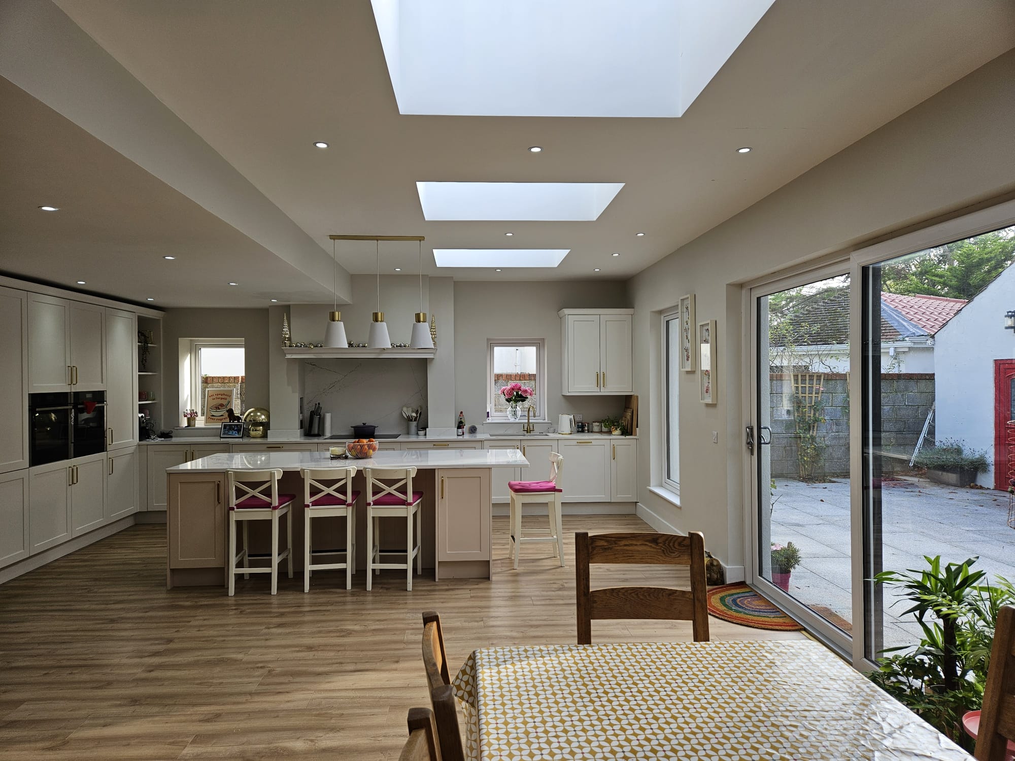 Contemporary kitchen extension with island, skylights and sliding doors to patio