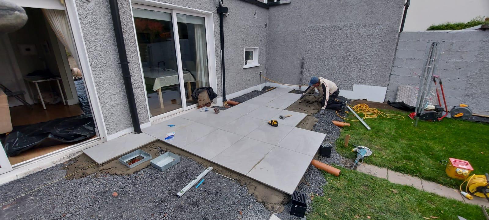 Porcelain slabs being laid on a mortar bed during construction