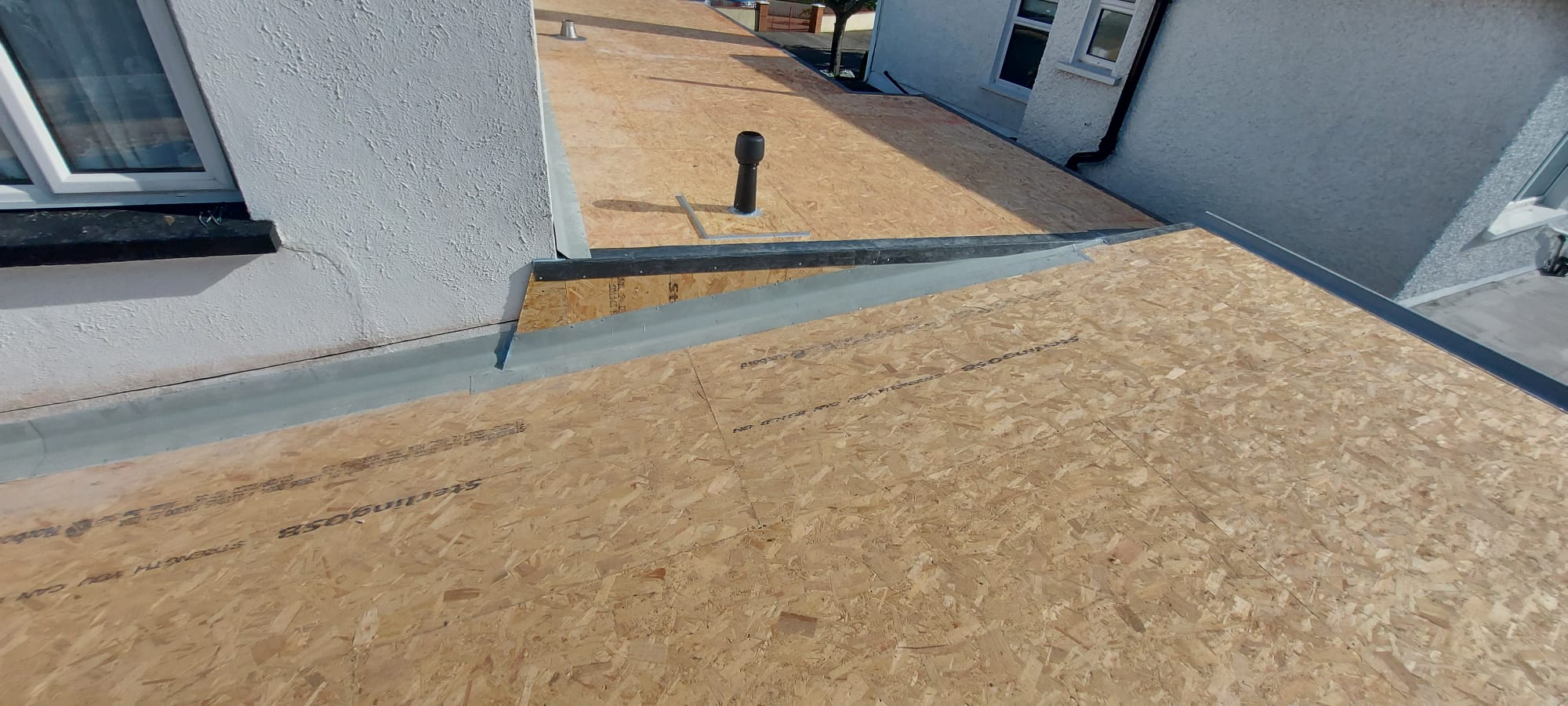 Close-up of OSB roof deck, flashing and vent pipe detail